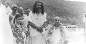 Swami Sivananda with devotees by riverside image