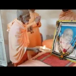 Devotees performing Puja before revered spiritual guru portrait with aarti