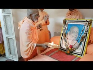 Devotees performing Puja before revered spiritual guru portrait with aarti