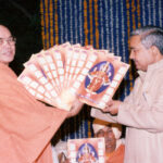 Bhakti teacher presenting devotional books during spiritual gathering with devotees together