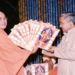 Bhakti teacher presenting devotional books during spiritual gathering with devotees together