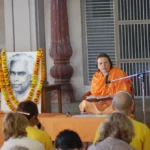 Swami Durgananda delivering a spiritual lecture before devotees at an ashram