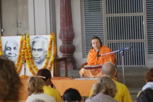 Swami Durgananda delivering a spiritual lecture before devotees at an ashram