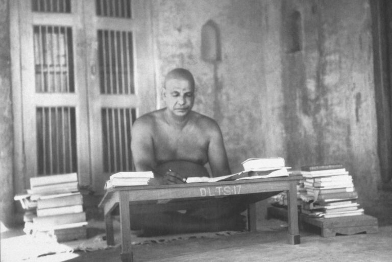 Swami Sivananda studying and writing spiritual teachings