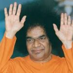 Bhagawan Sri Sathya Sai Baba raising both hands blessing devotees