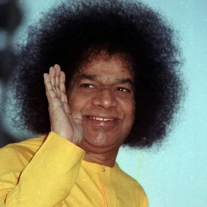 Bhagawan Sri Sathya Sai Baba giving a loving blessing with raised hand