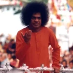 Sri Sathya Sai Baba blessing devotees with raised divine hand
