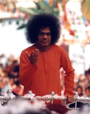 Sri Sathya Sai Baba blessing devotees with raised divine hand