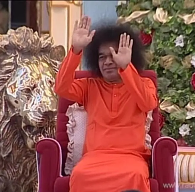Sri Sathya Sai Baba blessing devotees with raised compassionate hands